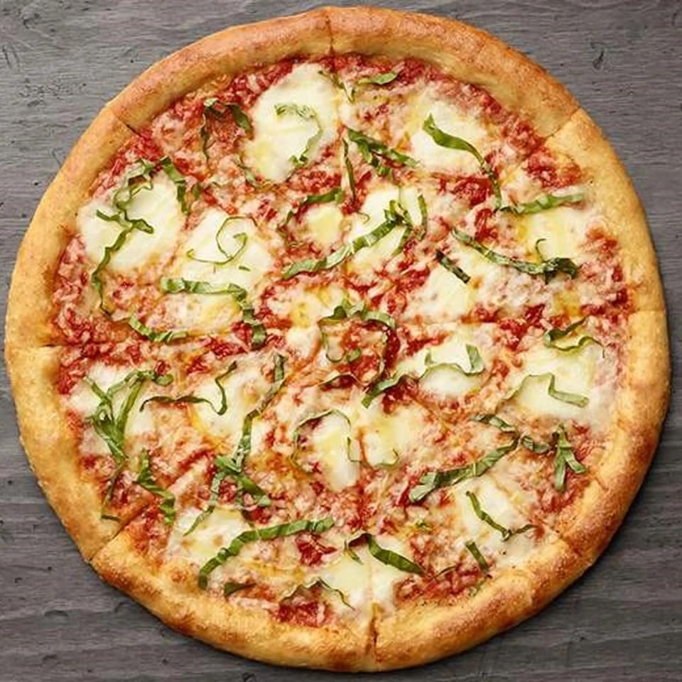 Paisano's Pizza Margherita, with fresh mozzarella, tomato sauce, and basil on a dark surface.